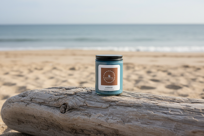 Candle on a piece of driftwood with a beach background