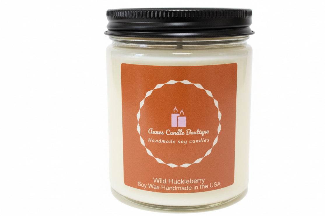 Candle jar with a black lid and orange label on a white background